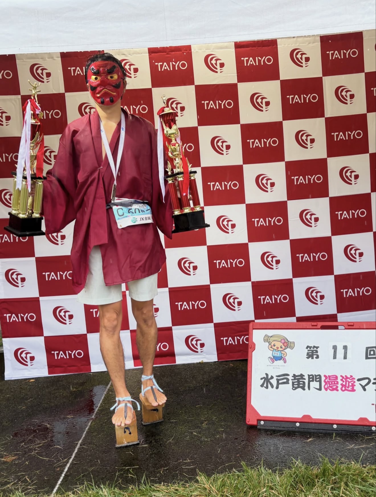 天狗の面を着け、二つのトロフィーを手にしたippon bladeのランナー